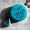 Dragonfly Bliss Coin Purse in bright blue with butterfly cutout design, featuring a tassel keychain, on a textured gray