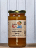 Georgia Peach Butter 14.5 oz jar with a gold lid, filled with peach-colored peach butter, against a white wooden background.