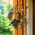 Green Witch Moon Sun Catcher with a witch sitting on a crescent moon, surrounded by colorful flowers and hanging decorative
