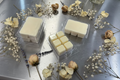 Lavender Soy Candle – Relaxing and calming scented candles in white wax, displayed with dried flowers on a metallic surface.