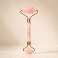Rose Quartz Facial Roller with pink stone and rose gold accents for facial massage and skincare.