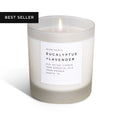 Eucalyptus Lavender Signature Soy Candle in a white container with lit wick and label displaying scent and details.