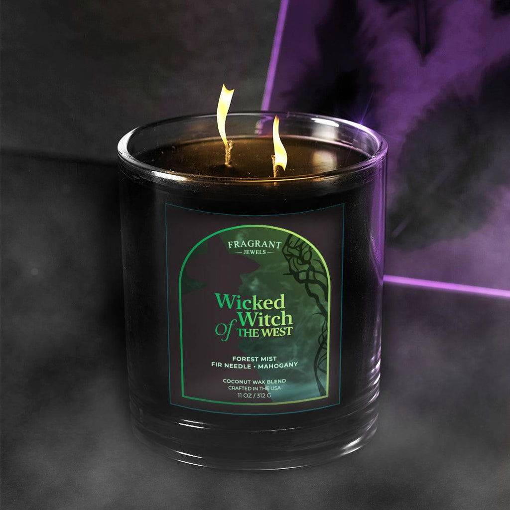 Wicked Witch of the West Jewel Candle with black glass container, green and black label, and burning wick with yellow flames.