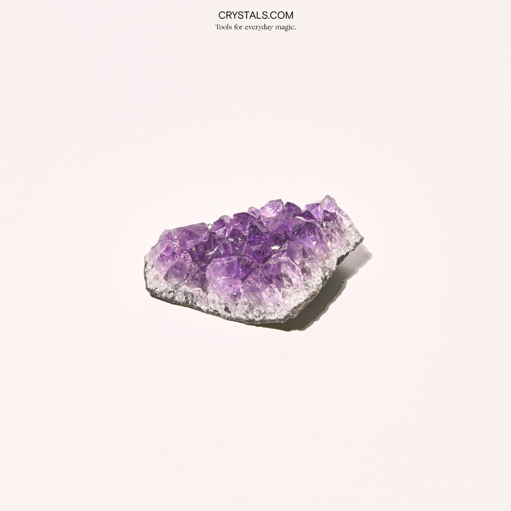 Amethyst Cluster with purple crystalline formations on a white background.