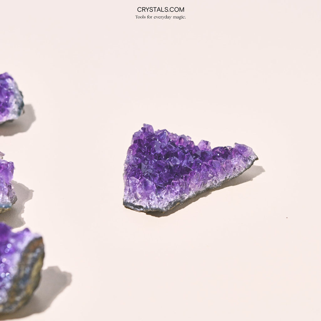 Amethyst Cluster showing purple crystalline formations on a gray base, natural mineral specimen for decoration or collection.