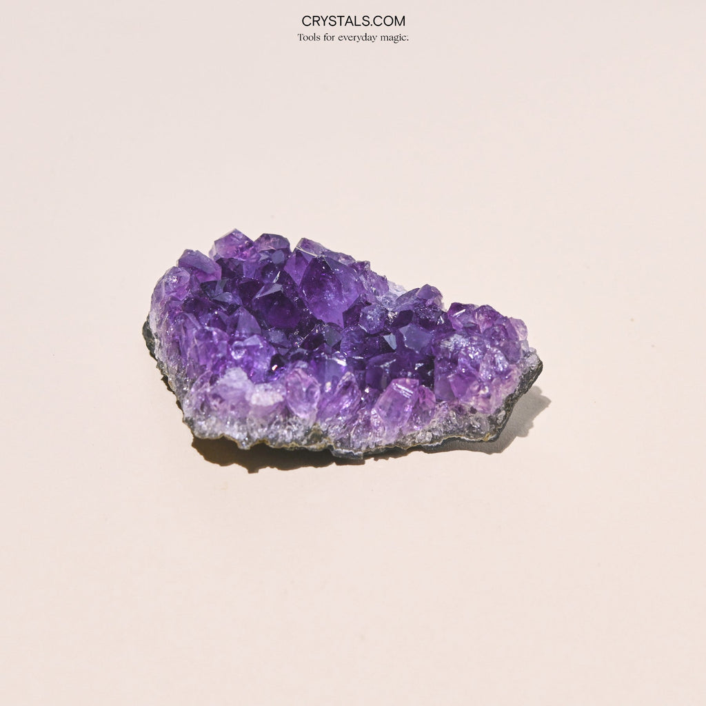 Amethyst Cluster with purple crystalline formations on a black base, used for decoration or energy healing.