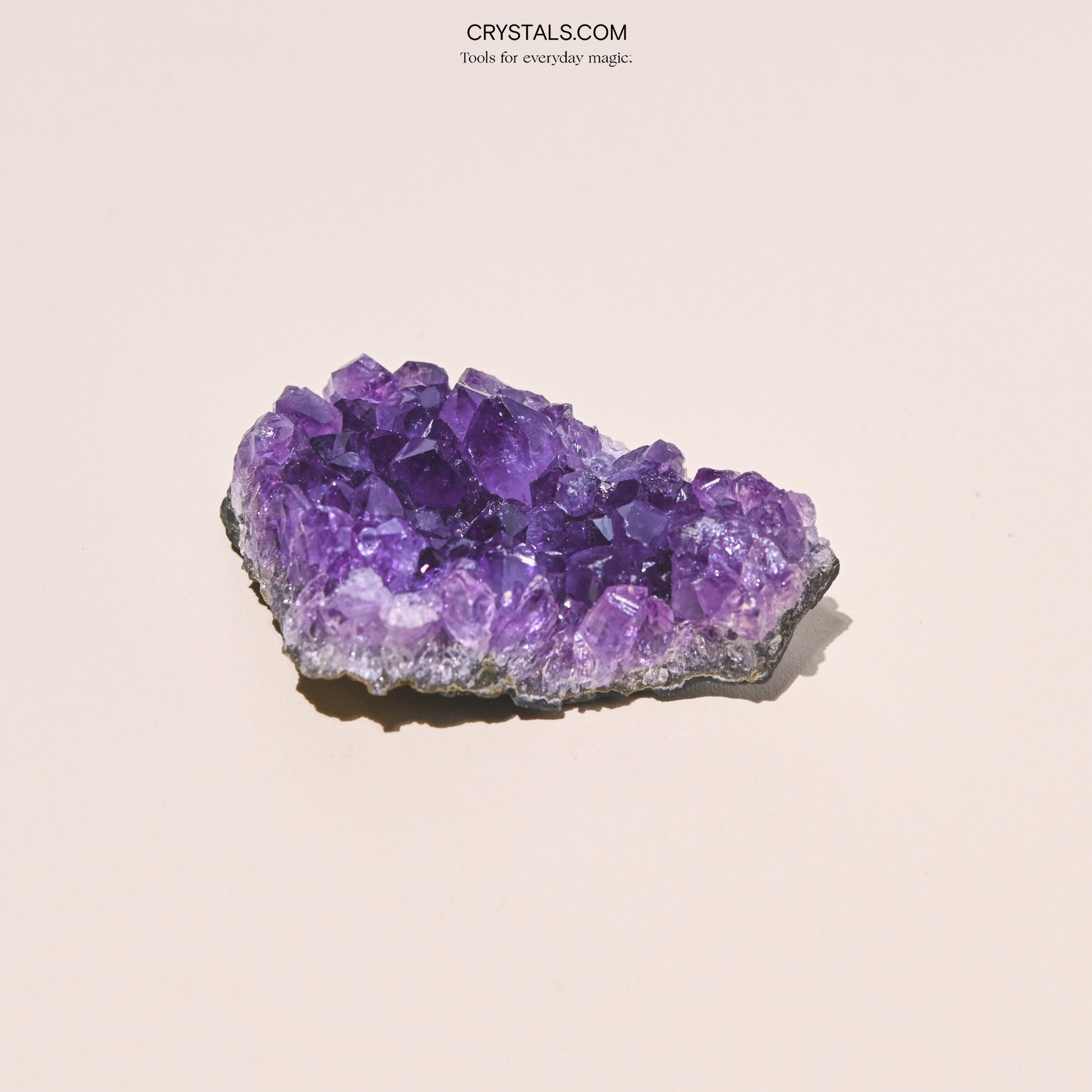 Amethyst Cluster with purple crystalline formations on a black base, used for decoration or energy healing.