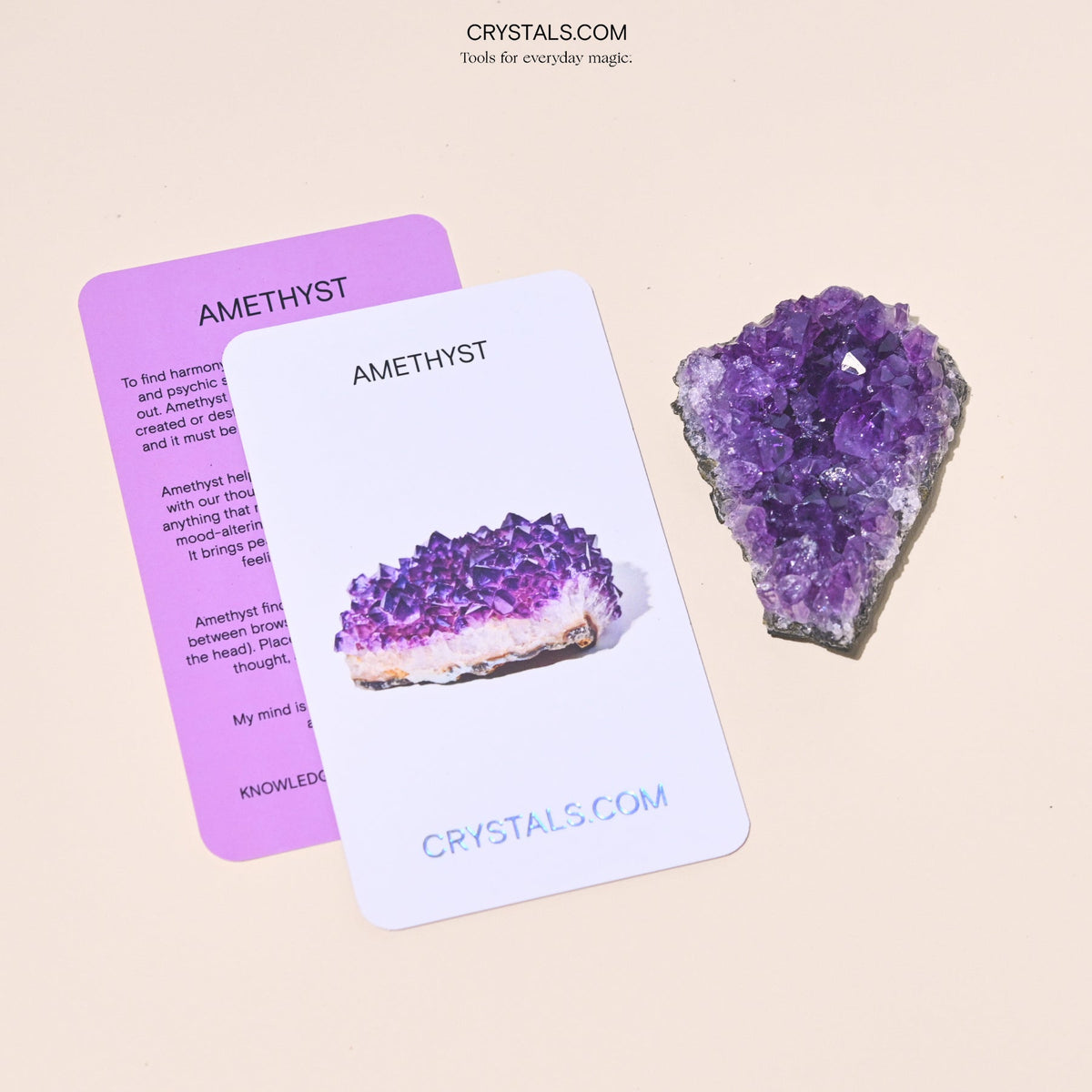 Purple amethyst cluster with sparkling crystals on a dark base, displayed next to informational cards.