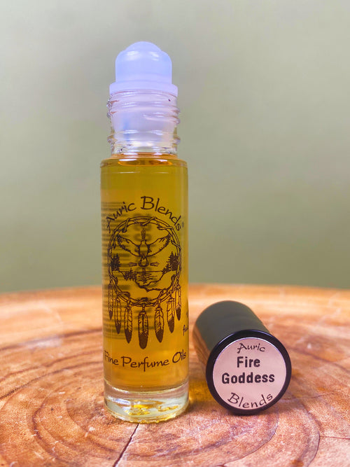 Fire Goddess Roll-on Perfume Oil in a small transparent glass bottle with a white rollerball, yellow liquid, and a black lid