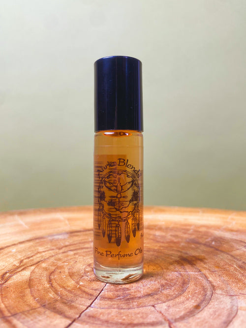 Forbidden Desire Roll-on Perfume Oil bottle with a black cap, featuring a dreamcatcher design, placed on a wooden surface.