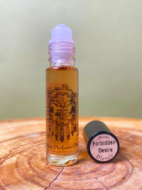 Forbidden Desire Roll-on Perfume Oil in a clear glass bottle with a black cap, featuring a dreamcatcher illustration and