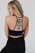 Peace Dreamcatcher Tattoo Bralette in black with a dreamcatcher design on the back, worn by a woman with blonde hair