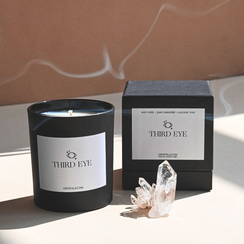 Third Eye Candle in a black container with white label, accompanied by a clear crystal and black packaging box.