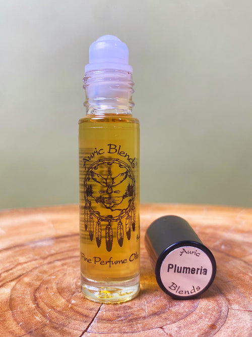 Plumeria Roll-on Perfume Oil in a clear glass rollerball bottle with a white cap, featuring black printed design and yellow